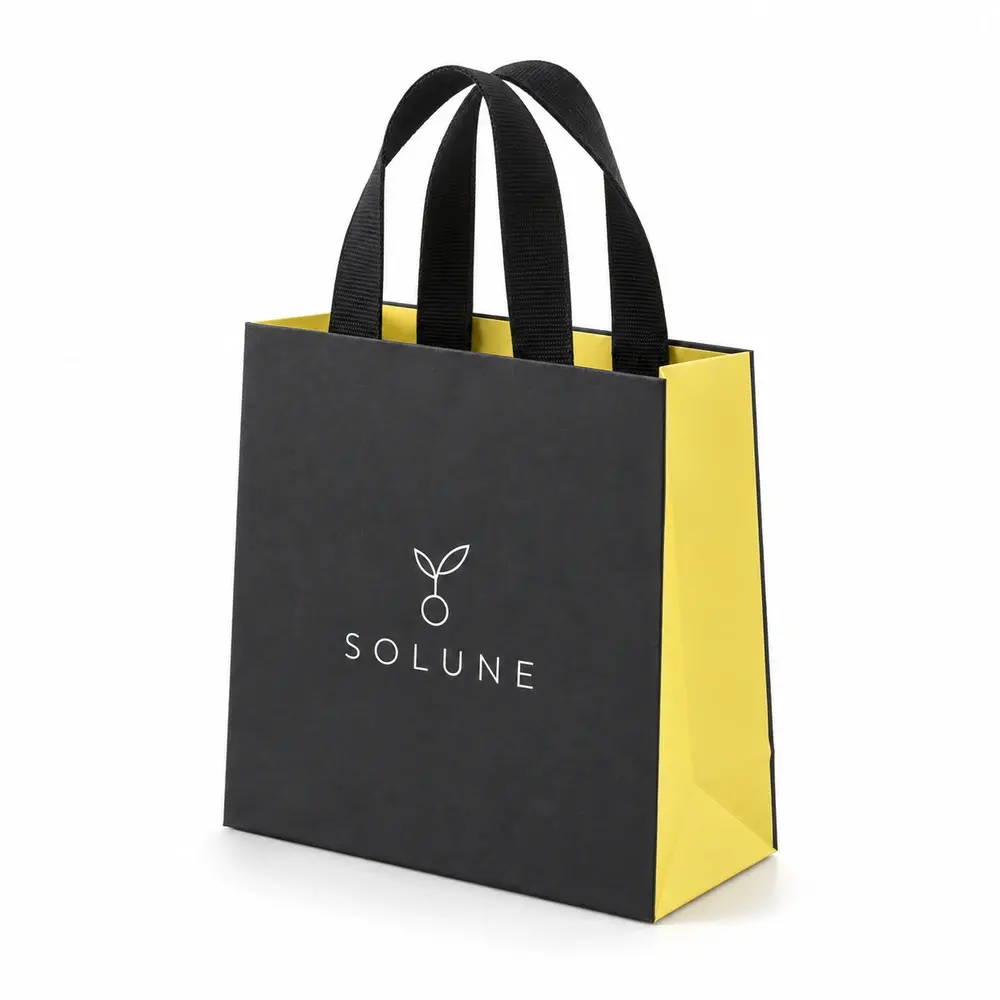 Alternate view of the charcoal with lemon yellow accents ribbon-handle gift bags with SOLUNE artwork
